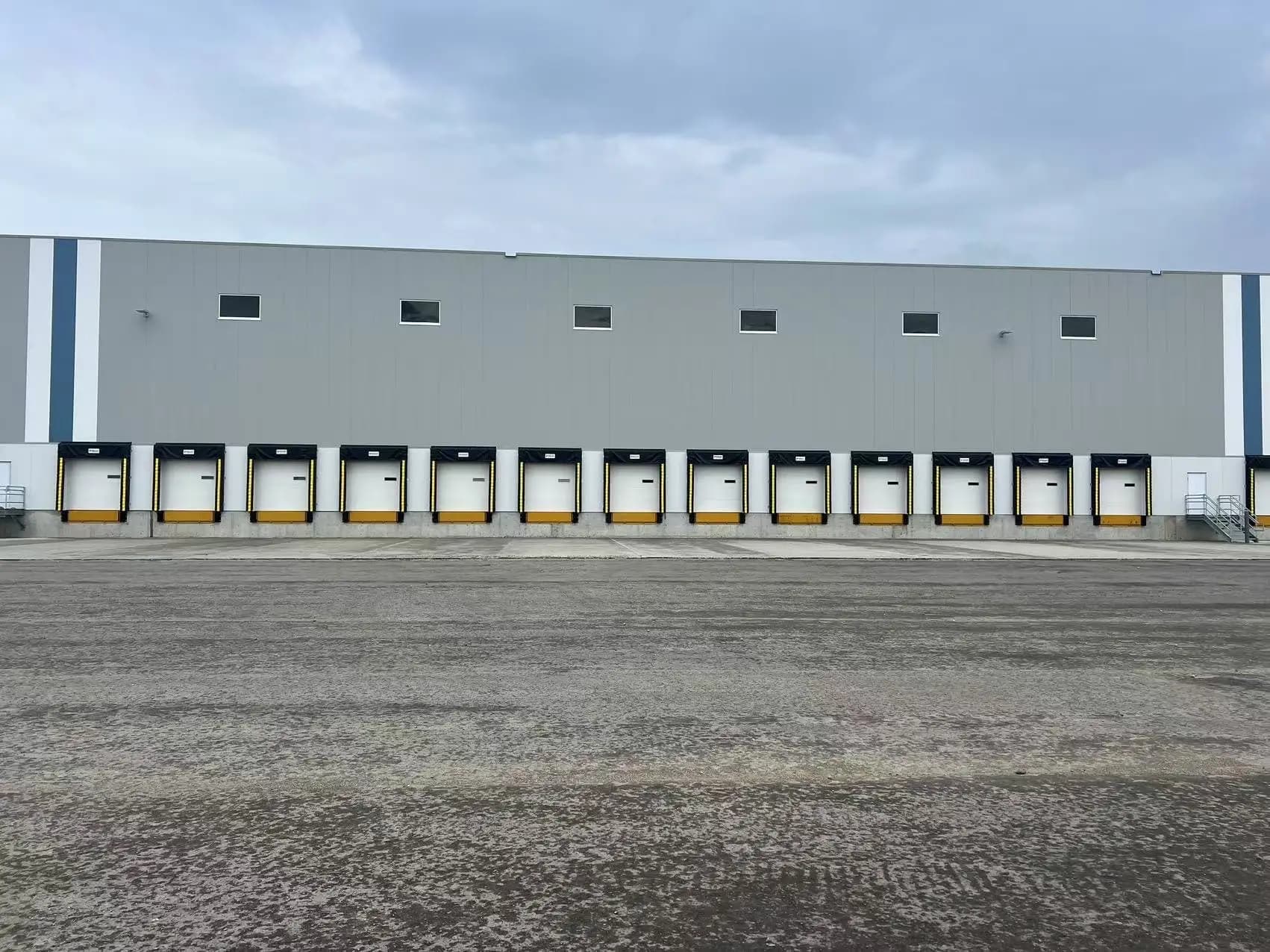 A long row of dock doors along a warehouse wall
