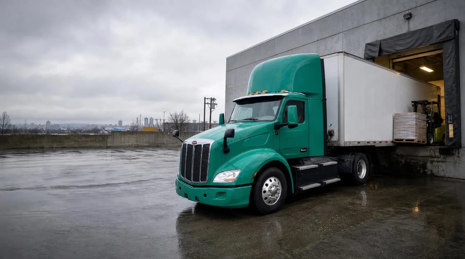Battery-electric truck backed up to a warehouse dock